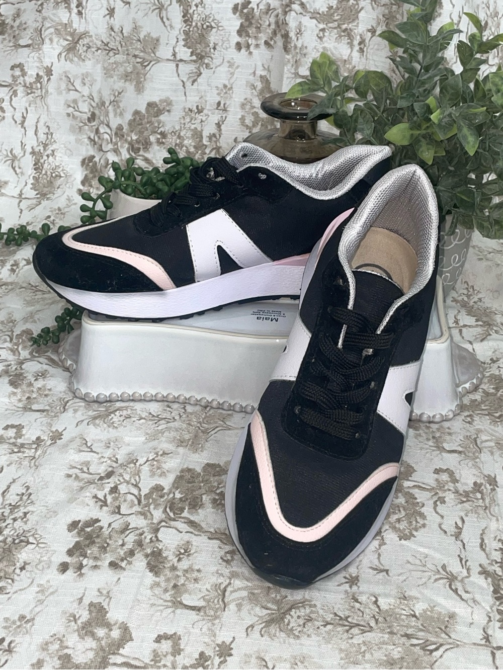 Classic Black and White sneakers with pink stripe.